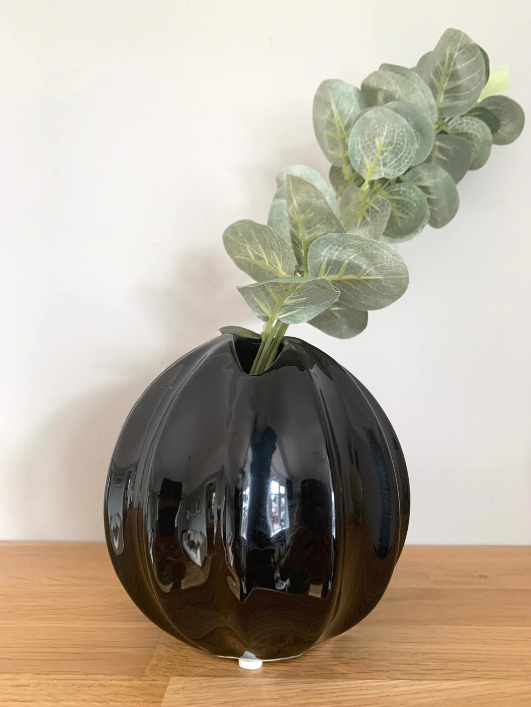 a round contemporary bud vase with a tilted opening