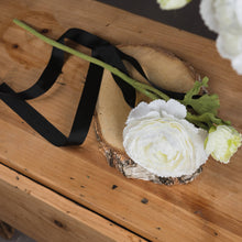 Load image into Gallery viewer, white ranunculous spray comprising of one open large flower head, one flower bud and delicate ranunculous leaves on a textured stem, placed on top of a wooden table, lying down
