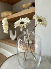 Load image into Gallery viewer, Tall curved glass vase styled on a coffee table with 3 Gerber flower stems placed in it
