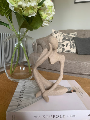 stone effect thinking figure, styled on top of a book on a coffee table