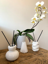 Load image into Gallery viewer, A gloss reed diffuser vessel in grey or white with a wave design around the edge. 
