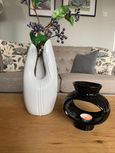 Load image into Gallery viewer, A gloss white contemporary case with a curved opening at the front and ribbed detailing half way around the vase and the other half smooth gloss
